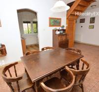 Dining room in a family house with wooden furniture and decor, entrance to the kitchen.