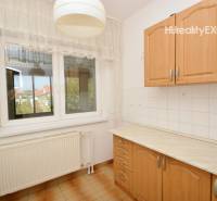 A kitchen in a family house with a simple kitchen unit and tiles.