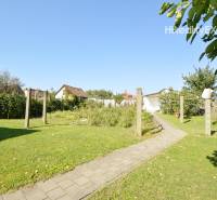 Garden area with lawn in a family house in Hegyeshalom, with a concrete walkway.
