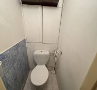 A bathroom with a standing bowl and blue tiles in a two-room apartment.