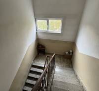 A staircase with a wooden railing in a 2-room apartment, an interior space with a window.