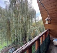 A balcony at a cottage in Dolné Rykynčice with a view of greenery and wooden decor.