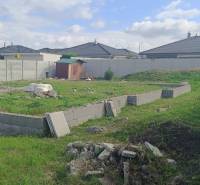 A plot for residential use in the Mládežnícka district in Galanta, surrounding houses and vegetation.