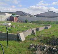 A residential plot in the Youth District of Galanta with a green area and a fence.