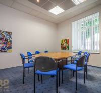 A kitchen in a building with a wooden decor floor and carpeted stairs.