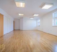 The interior of a building with a spiral staircase and upholstered carpet, railing, and wooden doors.