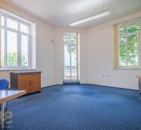 Office with shelves, desks, and computers in a building.