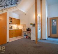 Meeting room with a round table, blue chairs, and abstract art on the walls.