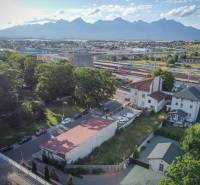 Building on Halatova Street in Poprad with advertising banners and an adjacent residential structure.