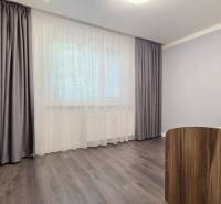 A bedroom in a 3-room apartment with a bed and a floor with a wooden decor.