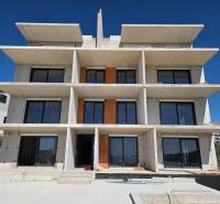 A multi-story building with large windows in Primošten, suitable for a 3-bedroom apartment.