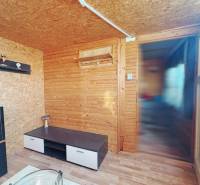 Wooden interior with a shelf and a table on the floor with a wooden decor in the Gardens.