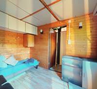 A room with a sofa, storage space, and a wooden decor floor in the Gardens.