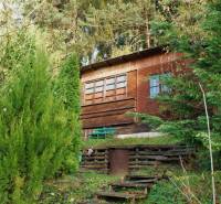 Wooden cottage surrounded by dense greenery in the Gardens on Budatínska Street in Žilina.