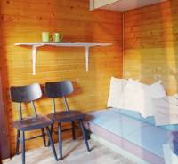 Wooden interior with chairs, a sofa, and a shelf with mugs, Gardens.