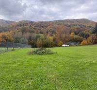 Green landscape on residential land in Zbor near Púchov with a mountain view.
