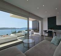 Interior of a villa with a sea view, wooden decor flooring, large windows.