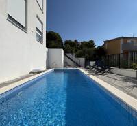 A pool in a villa in Trogir with loungers and walls in white design.