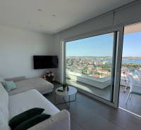 Living room in a villa with a sofa, television, and a view of Trogir and the sea.