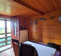 The interior of a wooden cabin with doors to the terrace and decorations on the walls in the gardens.