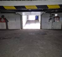 Interior of a garage with an exit, stone-patterned floor, light on Medená in Bratislava.