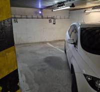 Parking spaces in garages with markings on the walls and yellow pillars.