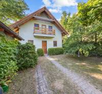 A family house on Senecká Street in Pezinok surrounded by greenery and a sidewalk.