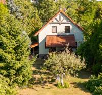 A family house on Senecká Street in Pezinok surrounded by trees and a garden with a lawn.