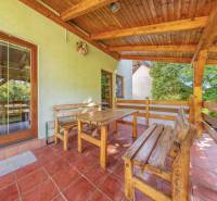 Wooden seating on the terrace of a family house with a view of the garden.