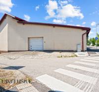 Commercial premises in Dunajská Streda with garage doors and an adjacent sidewalk.