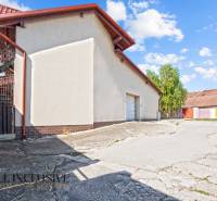 Commercial premises in Dunajská Streda with a white facade, metal roof, next to the sidewalk.