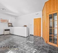 Interior of commercial spaces with white walls, black tiles, and wooden doors.