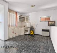 Interior of a kitchen with a corner unit and black tiles in commercial premises.