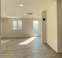 Interior with wood-patterned flooring in a family house. Lighting through two windows.