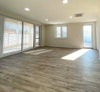 Living room in a family house with spacious windows and a wooden decor floor.