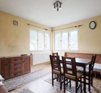 Dining room in a family house with a wood-patterned floor and a large window.