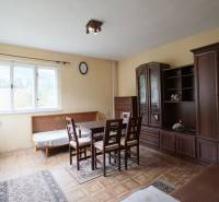 A living room in a family house with light furniture and a wooden decor floor.