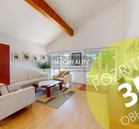 Living room in a family house with wood-patterned flooring, comfortable seating, and decorations.