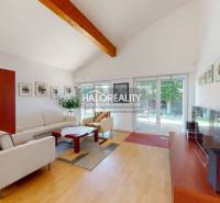 Living room in a family house with comfortable seating, wooden decor, and large windows.