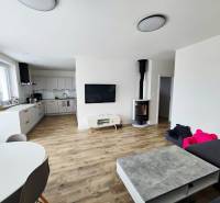 Living room in a family house with a kitchenette and a wooden decor floor.