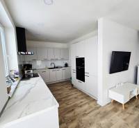 The kitchen and living area of the family house with a wooden decor floor.