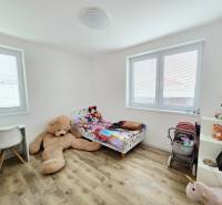 Children's room with a bed, a desk, and a floor with a wooden decor in a family house.