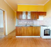 A room in a 2-room apartment with a wooden decor floor and large windows.
