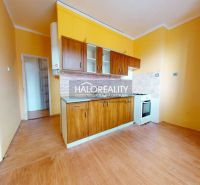 A kitchen unit in a 2-room apartment with a wooden decor floor.