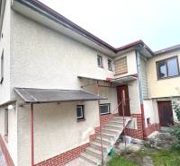 A family house in Tvrdošín with a floor and a staircase, greenery in front of the house.