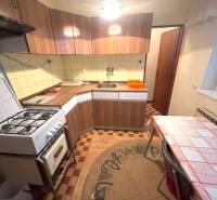 Kuchyňa v rodinnom dome s plynovým sporákom a podlahou s dreveným dekorom.