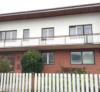 Rodinný dom na Vladine v Tvrdošíne s tehlovým obkladom a bielym plotom.