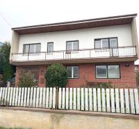 Rodinný dom na ulici Vladina v Tvrdošíne s bielym plotom a tehlovou fasádou.