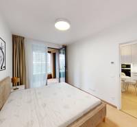 Bedroom in a 2-room apartment with a bed, decorative paintings, and a view of the loggia.