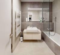 Bathroom in a 2-room apartment with a bathtub, mirror, and sink.